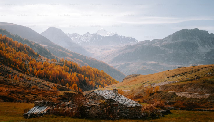 Maison de pierre au pied des montagnes à l'automne